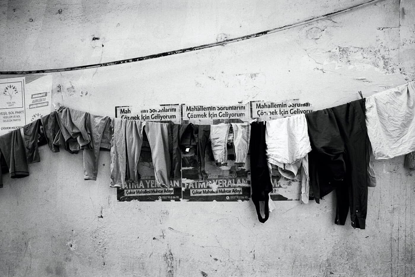 Laundry hanging on a wall in front of political campaign posters