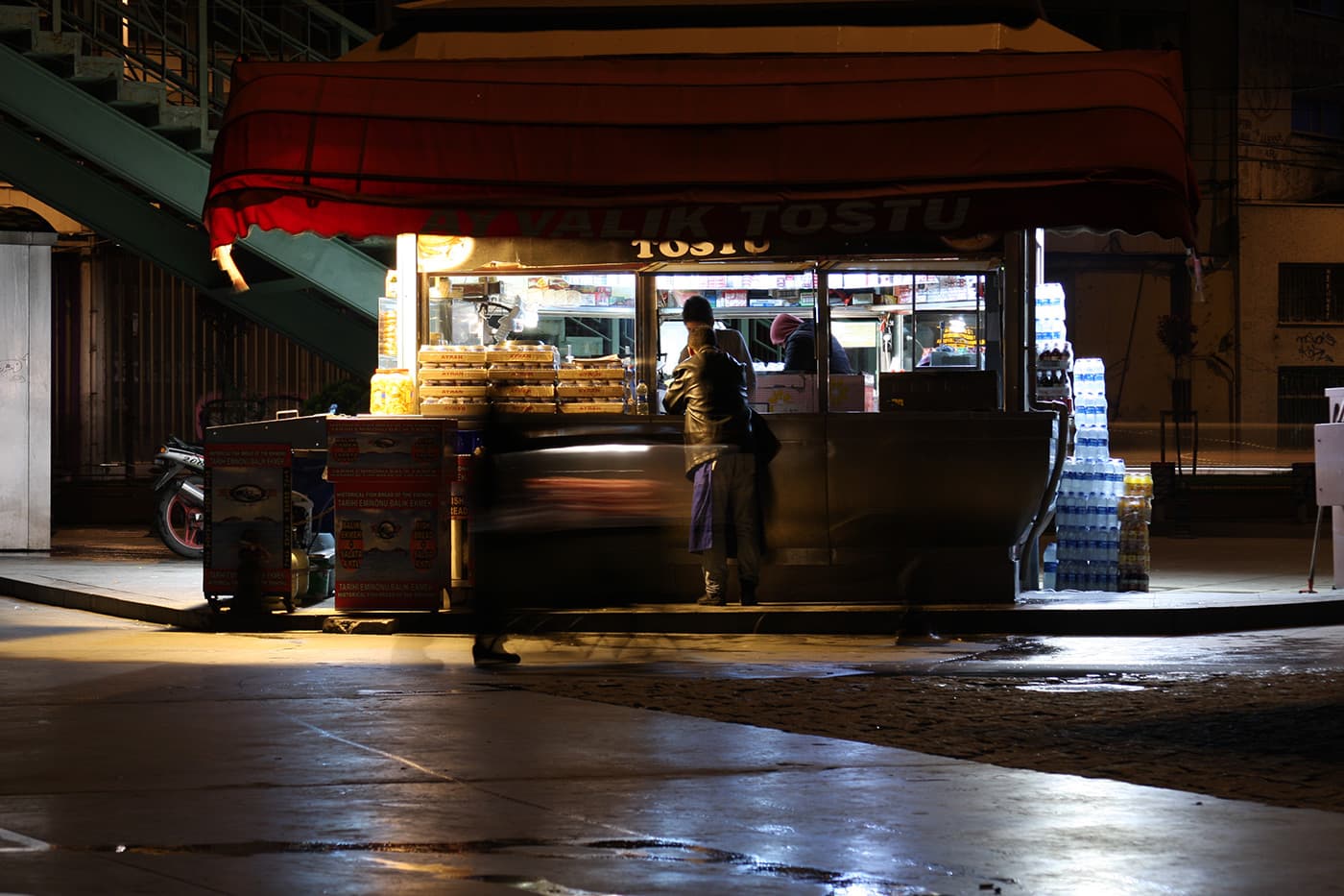 Street food pavilion with long exposure and blurred moving people around the stand