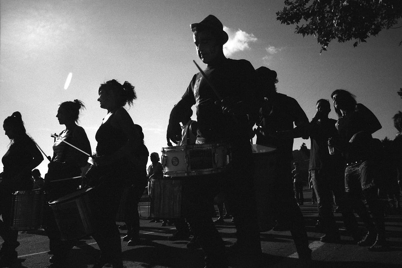 A batucada percussion group performing on a street