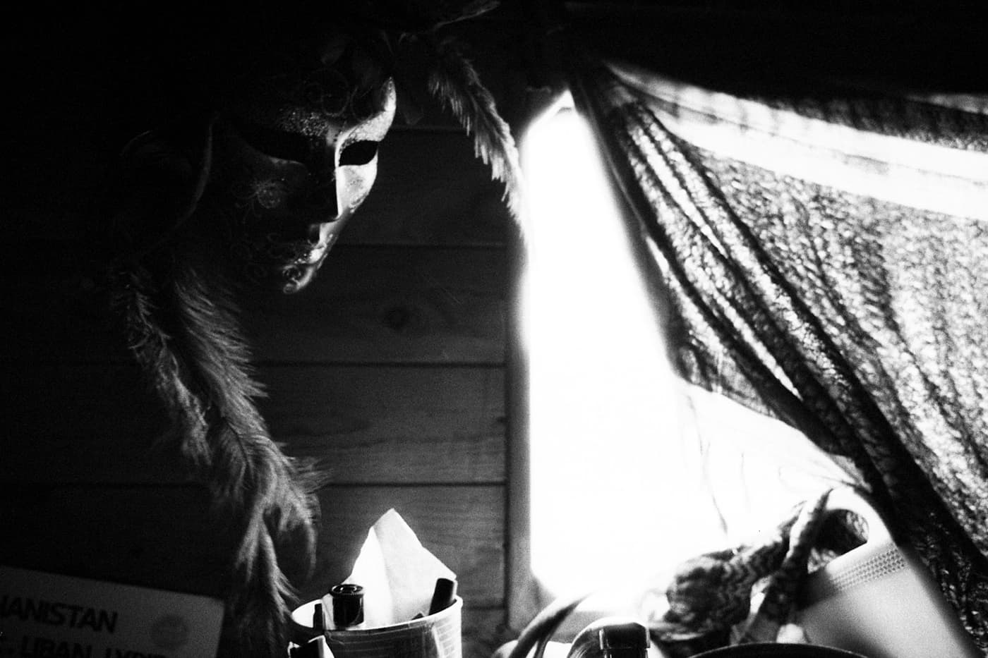 A caravan - part of a window covered with fabric and a mask with feathers