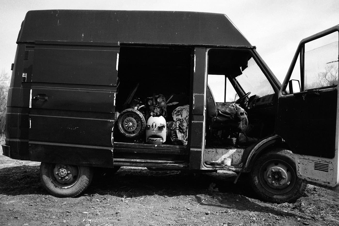 A bus with its side door open and a stack of different masks placed one over another inside