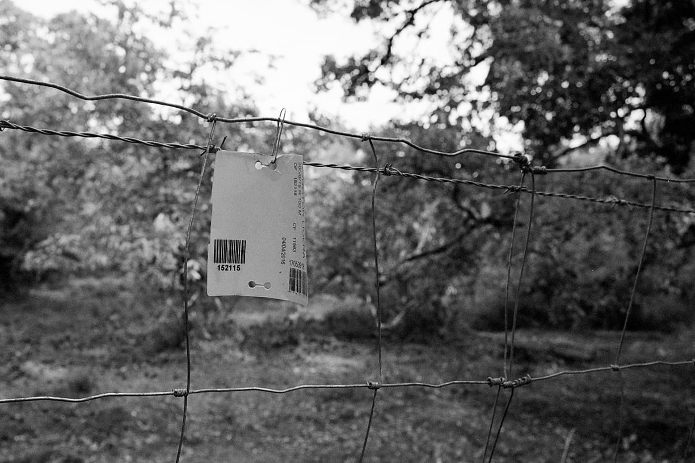 A close-up view of a fence with a price barcode sticker hanging on it