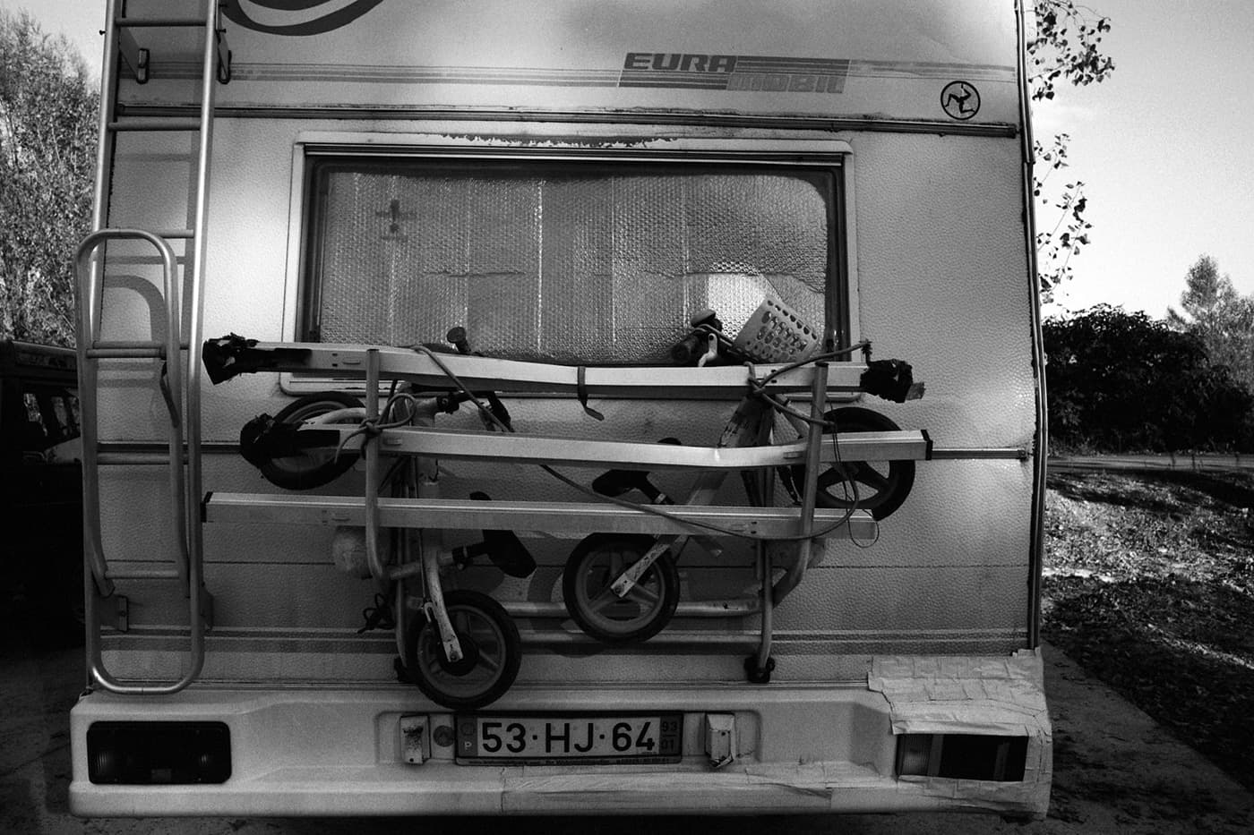 Rear view of a caravan with two children's bikes attached to a rack